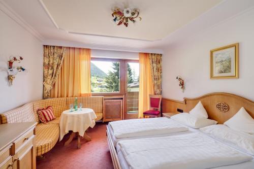 エルフェンドルフにあるUnser Berghofのベッド2台とテーブルが備わるホテルルームです。