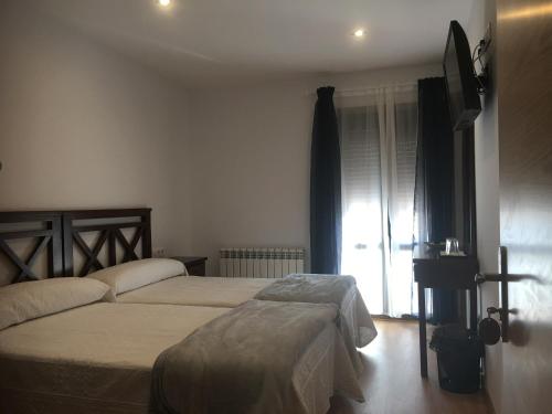 sypialnia z 2 łóżkami i oknem w obiekcie La Casa del Hilario w mieście Milagro
