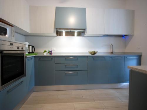 eine Küche mit blauen Schränken und weißen Geräten in der Unterkunft Villa Sabrina in Lignano Sabbiadoro