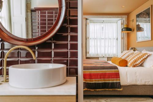 Gran Cruz House في بورتو: غرفة نوم بسرير ومرآة دائرية