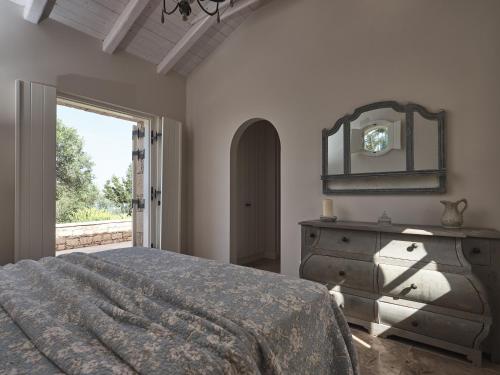 a bedroom with a bed and a mirror and a dresser at Lagaria in Skinária