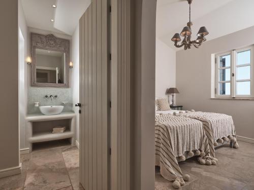 a bedroom with a bed and a sink and a mirror at Lagaria in Skinária