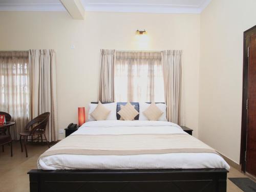 a bedroom with a large bed in front of a window at Bota Royal in Kushālnagar