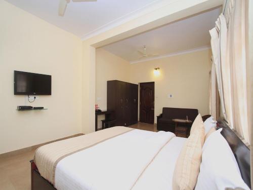 a hotel room with a bed and a television at Bota Royal in Kushālnagar