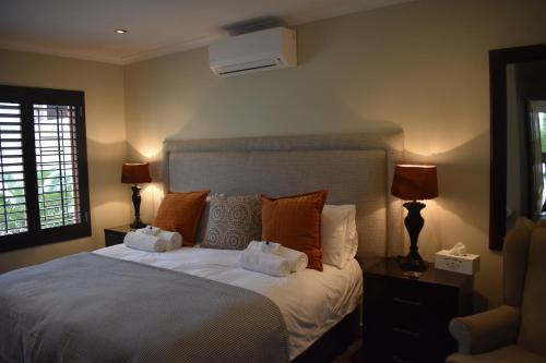 a bedroom with a large white bed with two lamps at Soeteweide North B&B and Spa in George