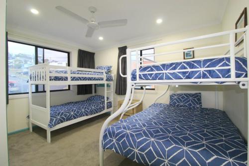 a bedroom with two bunk beds and a bed at Bombora, 3/4 East Street in Crescent Head