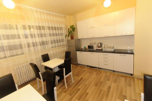 a kitchen with white cabinets and a table and chairs at Moon Hostel in Pristina