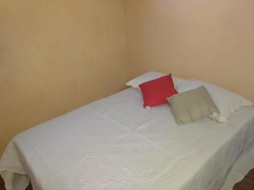 a white bed with two pillows on top of it at Hospedagem Amanhecer in Barreirinhas