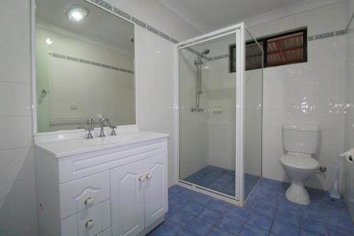 a bathroom with a shower and a sink and a toilet at Bombora, 3/4 East Street in Crescent Head