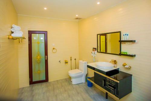 a bathroom with a toilet and a sink and a mirror at Euro Star Hotel in Katunayake