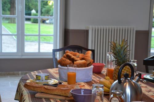 une table avec une corbeille de pain et du jus d'orange dans l'établissement Château de Saint Ouen les Vignes, à Saint-Ouen-les-Vignes