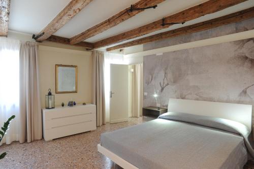 a bedroom with a bed and a stone wall at Cà Riva del Vin in Venice
