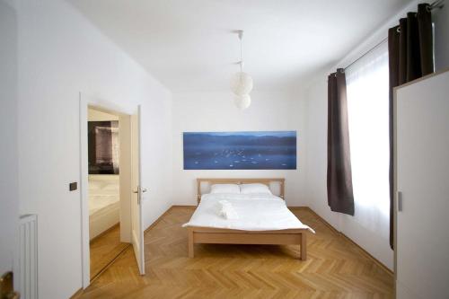 a white bedroom with a bed and a window at Skyscraper Apartment Tour As Ljubljana in Ljubljana