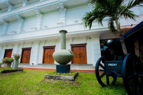 a statue in front of a building with a palm tree at Euro Star Hotel in Katunayake