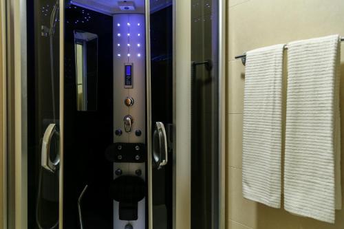 a bathroom with a glass shower with towels in it at Aquele Cantinho in Amadora