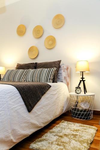 a bedroom with a bed and a wall with hats on the wall at Aquele Cantinho in Amadora
