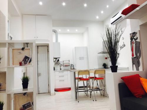 a kitchen with white cabinets and chairs in a room at Isola Flat in Milan