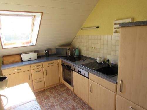 una cocina con fregadero y estufa en FeWo mit Balkon, Zimmermann, en Strasen