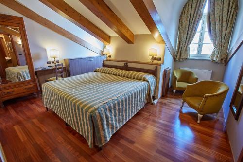 sypialnia z łóżkiem, krzesłem i oknem w obiekcie Liberty Hotel w Turynie