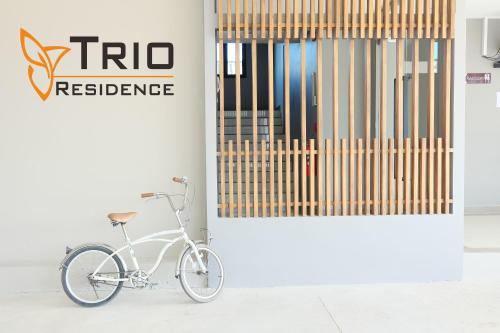 a white bike parked in front of a door at Trio Residence Si-Racha in Si Racha
