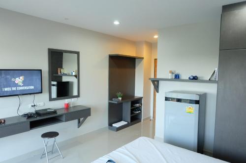 a room with a bed and a tv on a wall at Trio Residence Si-Racha in Si Racha