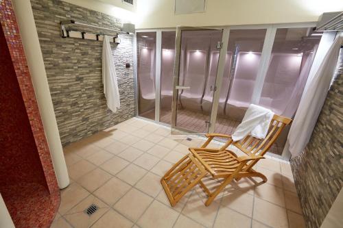 a bathroom with a shower and a rocking chair at Liberty Hotel in Turin