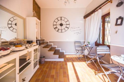 una cucina con scale e un orologio sul muro di B&B Il Folletto del Lago a Stresa