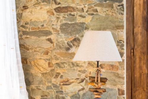 a lamp sitting in front of a stone wall at B&B Il Folletto del Lago in Stresa