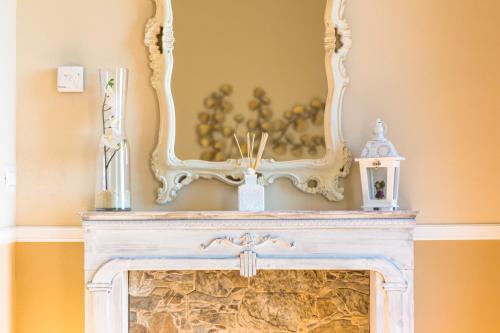 a white fireplace with a mirror above it at B&B Il Folletto del Lago in Stresa