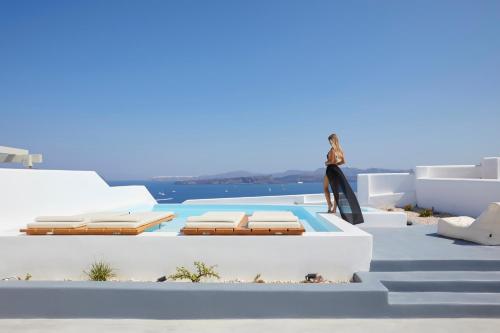 a woman is standing on the roof of a house at Phos The Boutique in Akrotiri