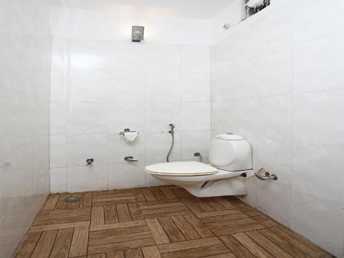 a white bathroom with a toilet in a room at Click Resort Corbett Tiger Den in Rāmnagar