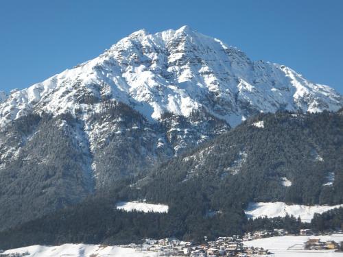 a snow covered mountain with a town in front of it at Haus Gantioler in Mieders