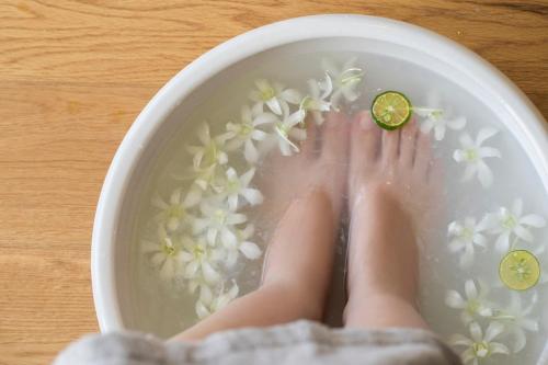 a person is standing in a bowl of water with flowers at Hyatt Regency Seragaki Island Okinawa in Onna