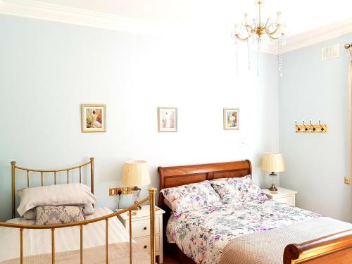- une chambre avec un lit et un lustre dans l'établissement Grove Cottage at The Lodge, à Tullow