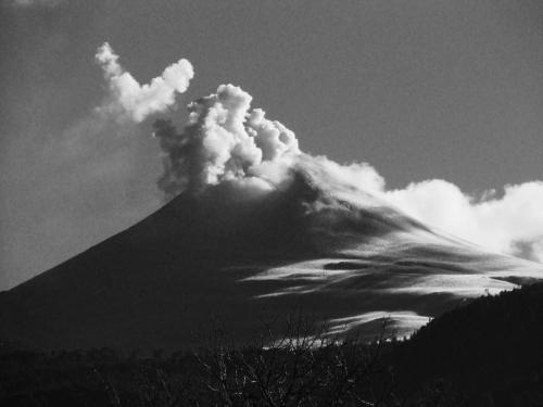 a mountain with smoke coming out of it at Cabanas L'ESCALE in Coñaripe