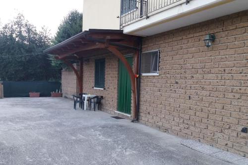 eine Terrasse mit Tischen und Stühlen unter einem Gebäude in der Unterkunft LE RIVE - Soggiorno/Vacanza a TUFO (Avellino) in Torrioni