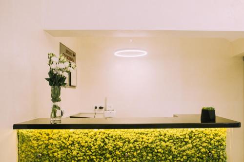 a yellow and black counter with a vase of flowers at Bolero plus in Mukacheve