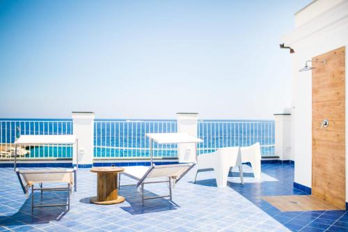 a patio with white chairs and tables on a ship at Zagma Un Passo Dal Mare in Canneto
