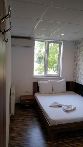 a bedroom with a white bed with a window at Hotel Viva in Ploieşti