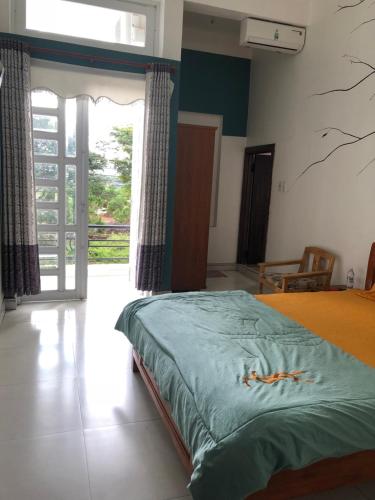 a bedroom with a bed and a sliding glass door at An Ngọc Linh Hotel in Bao Loc