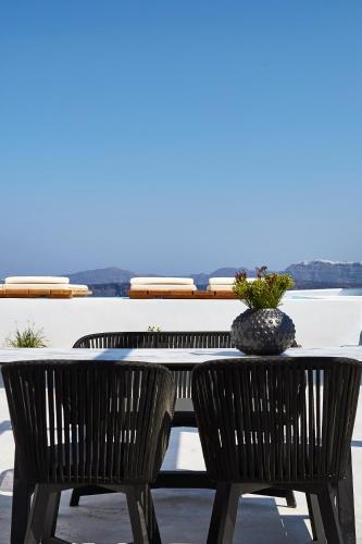 a table with two chairs and a vase on it at Phos The Boutique in Akrotiri