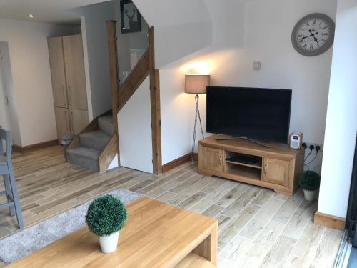 a living room with a flat screen tv and a table at No 4 Elizabeth Street in Congleton