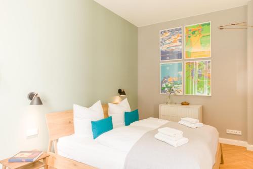 Un dormitorio con una cama blanca con toques azules en OSTKÜSTE - Nadler Hof Design Apartments, en Ahlbeck