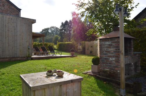 a garden with a table in the grass at Gîte Wellness "Le Poirier" in Durbuy