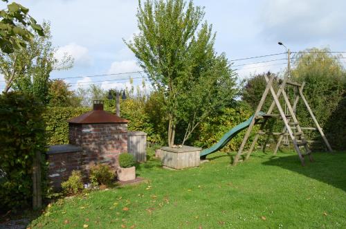 a playground with a slide in a yard at Gîte Wellness "Le Poirier" in Durbuy