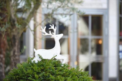 a white statue of a deer on top of a bush at Hotel Hirschen in Freiburg-Lehen in Freiburg im Breisgau