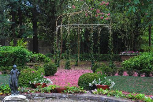 um jardim com uma estátua no meio com flores em La Striscia Wine Resort em Arezzo