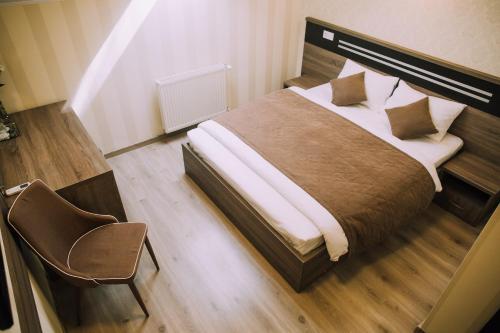 a bedroom with a large bed and a chair at Bolero plus in Mukacheve