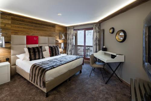 a bedroom with a bed and a desk and a desk at Hôtel Koh-I Nor by Les Etincelles in Val Thorens