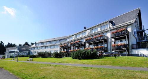 a large white building with flowers on the balconies at WAGNERS Sporthotel Oberhof in Oberhof